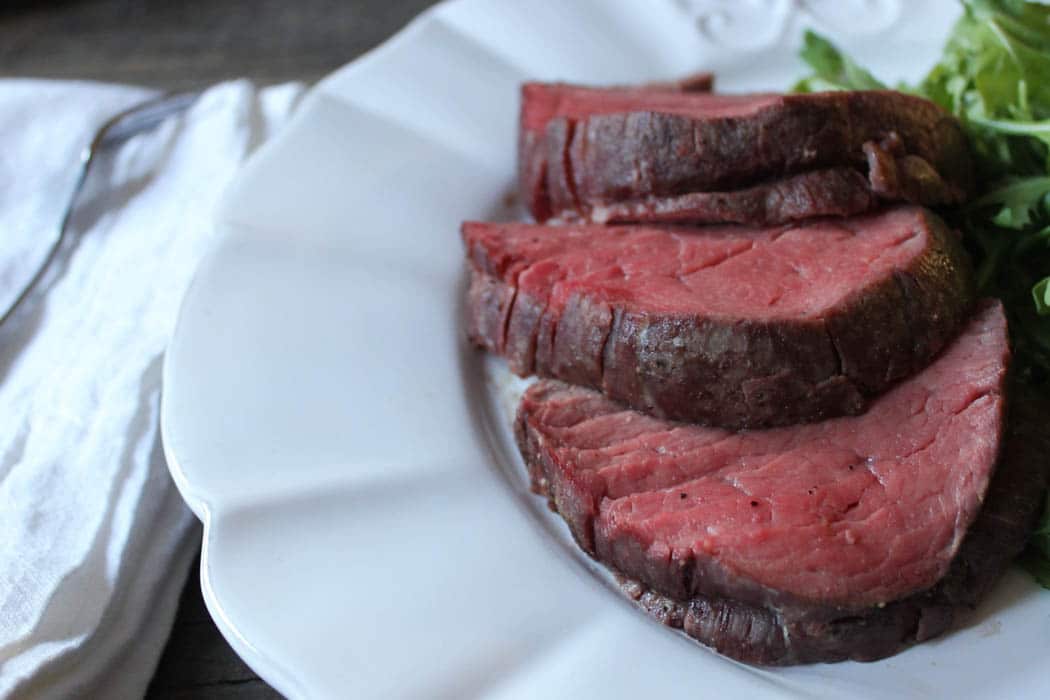 Close up of plated slow-roasted beef tenderloin with texture.