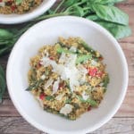 Bowl of quinoa topped with asparagus, and grated parmesan.