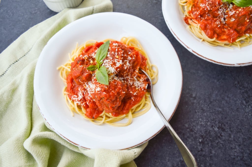 Close up of weeknight spaghetti and meatballs with marinara sauce with a napkin and fork.